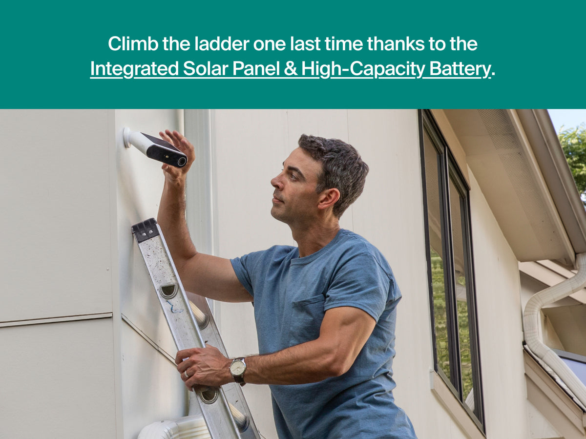 A man in a blue t-shirt climbs a ladder against a beige house exterior, holding a Arlo Essential Solar Security Camera. A teal banner at the top reads, 'Climb the ladder one last time thanks to the Integrated Solar Panel & High-Capacity Battery.