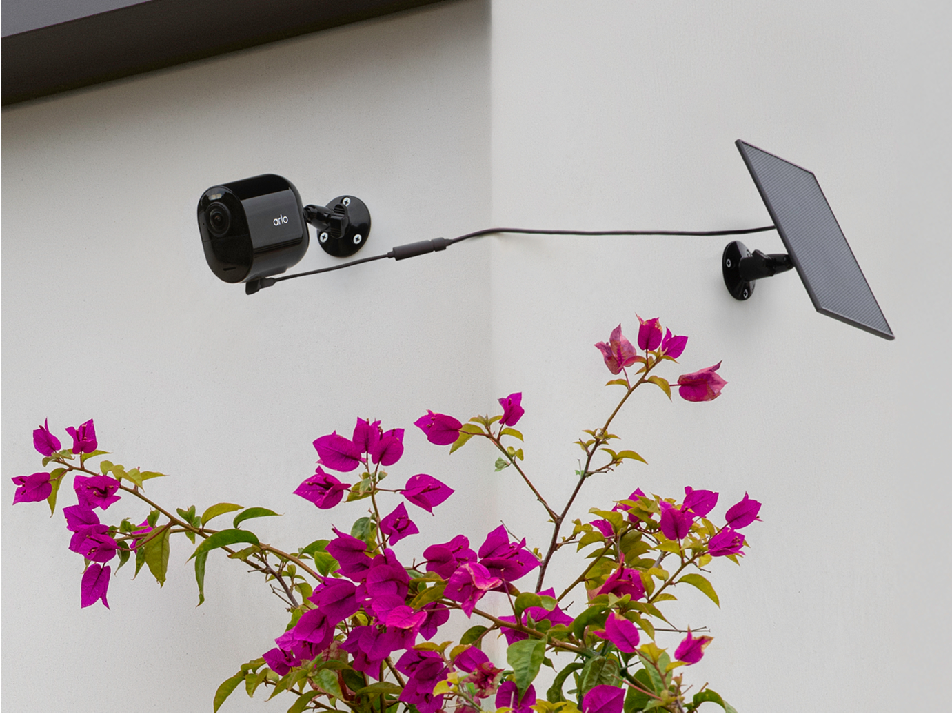 Arlo Ultra 3rd Gen camera in black with a black solar panel mounted on the side of a house