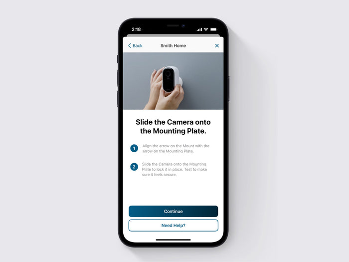 A hand mounting the Arlo Essential 2nd Gen XL camera on a wall on the screen of a phone