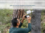 A man removing the rechargeable battery from the Arlo Go 2 camera mounted on a tree